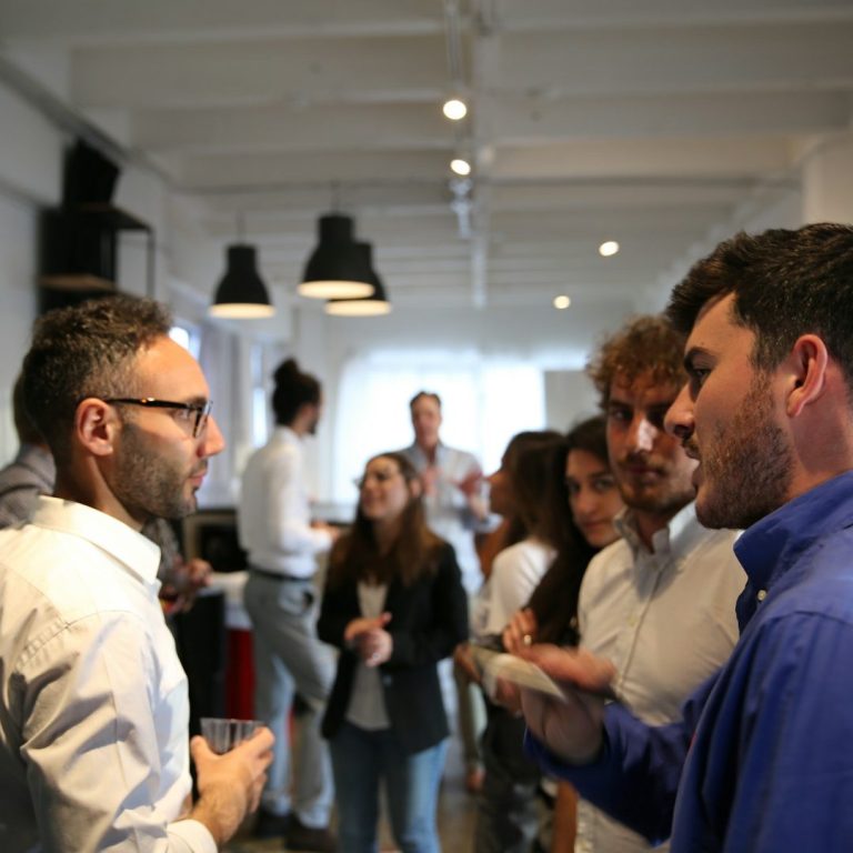 Networking Gruppe von Menschen in einem modernen Raum, die an einem Gespräch teilnehmen.